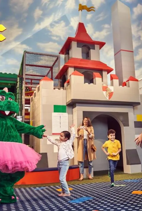 A human size lego parts inside legoland theme park with an entertaining mascot figure