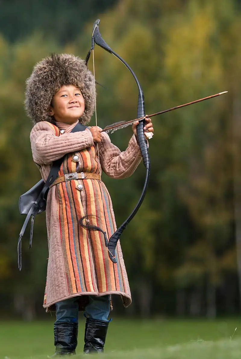 A kid holding an arrow in Kyrgystan