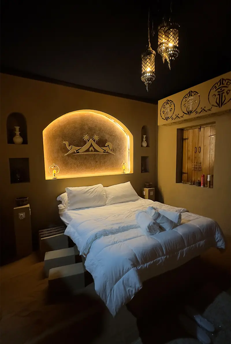 a comfortable white bed inside the camp of ras al khaimah desert
