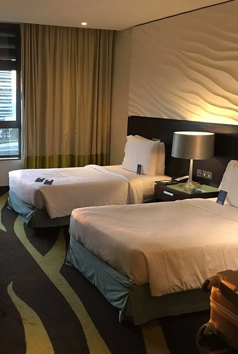 Double Bedrooms with a lamp on the middle inside Radisson Blue